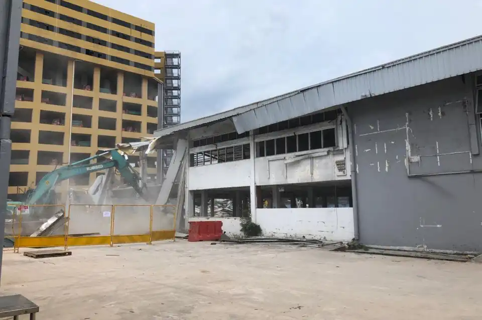 Excavator demolishing an industrial building